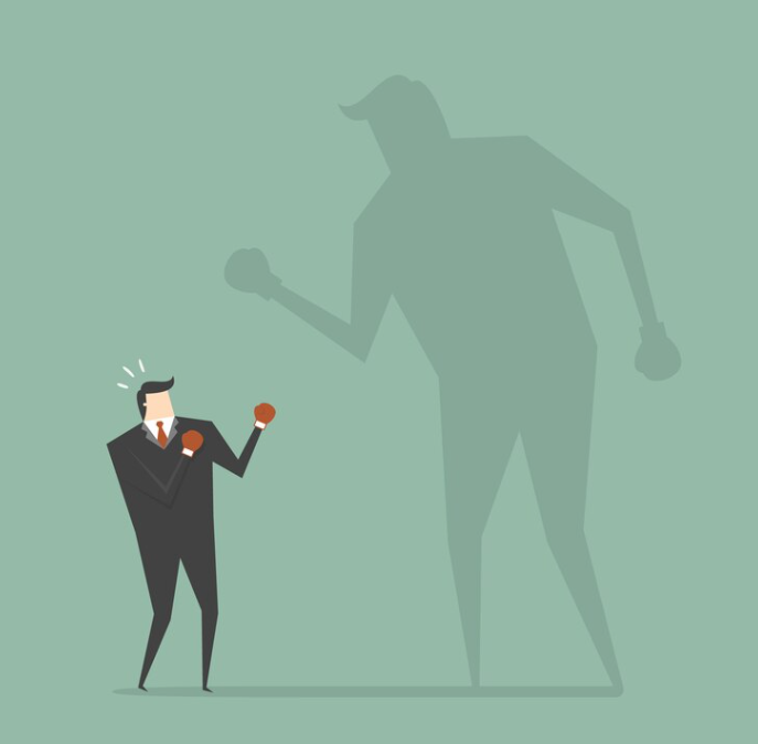 A businessman holding a small gavel stands in the shadow of a giant, imposing figure